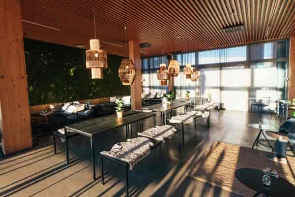 Häät at Ravintola Nokka: modern event space with natural wood and greenery, ideal for gatherings.
