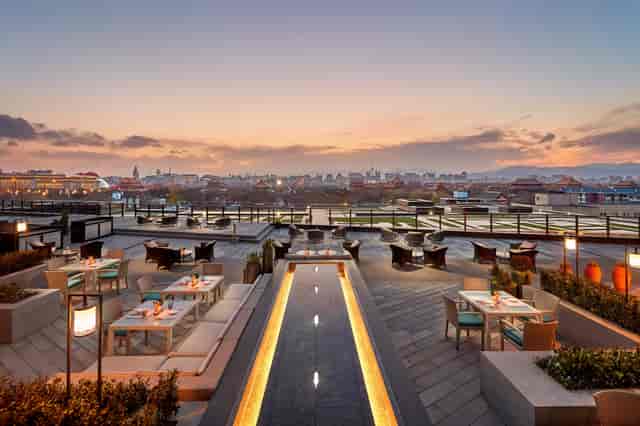 Rooftop restaurant at Mandarin Oriental Wangfujing, Beijing with panoramic sunset views.