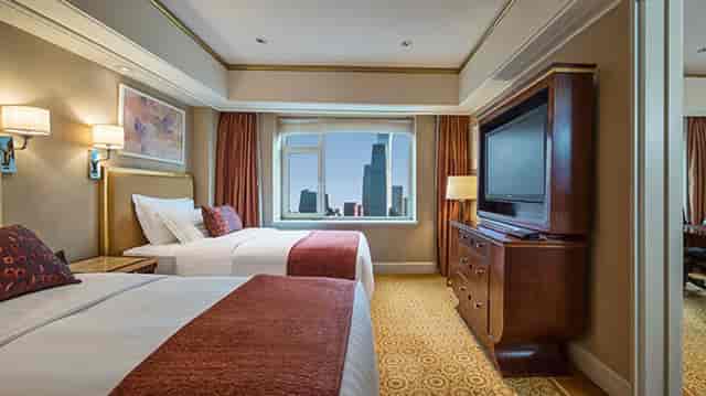 "Luxury hotel suite with dual beds at The St. Regis Beijing for corporate retreats."