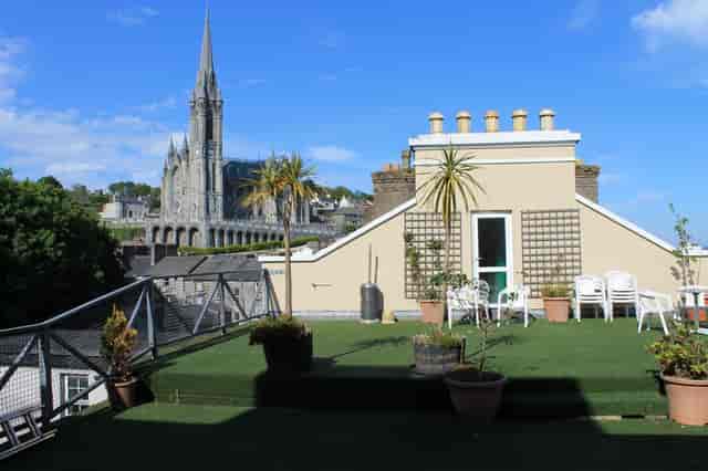 Rooftop garden at Commodore Hotel with church spire, ideal for summer events and gatherings.