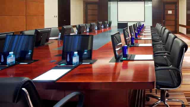 Modern conference room with wooden table, ideal for corporate meetings and presentations.