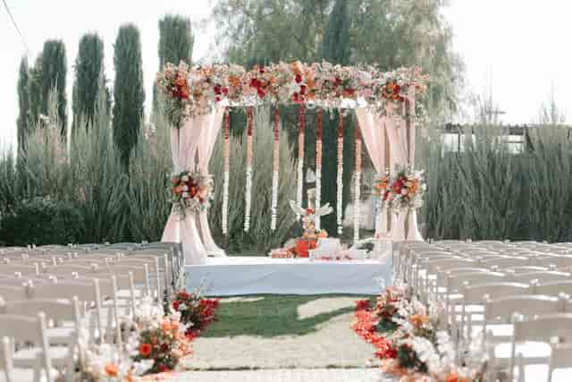 Outdoor wedding ceremony with floral arch at Palm Event Center, romantic venue.