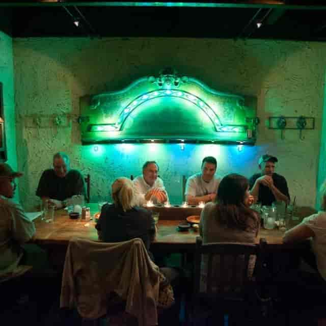 Cozy restaurant table with ambient green lighting for intimate gatherings or meetings.