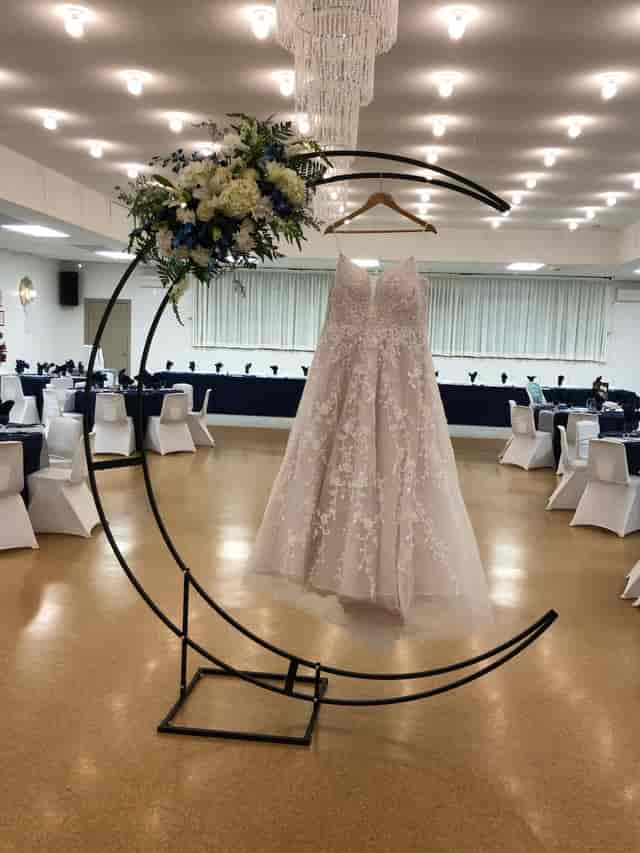 Elegant wedding setup at Belleville Fish and Game Club with stylish dress display.