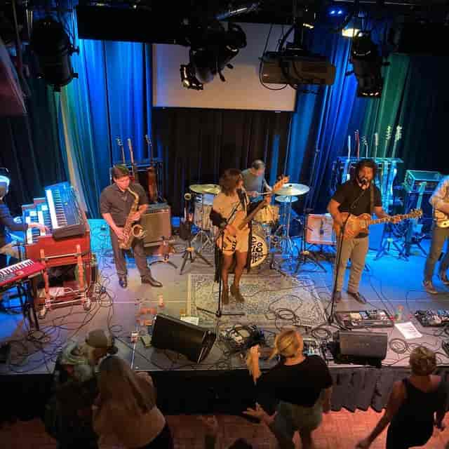 Vibrant live band performance with colorful lighting at a music venue in Redwood City.