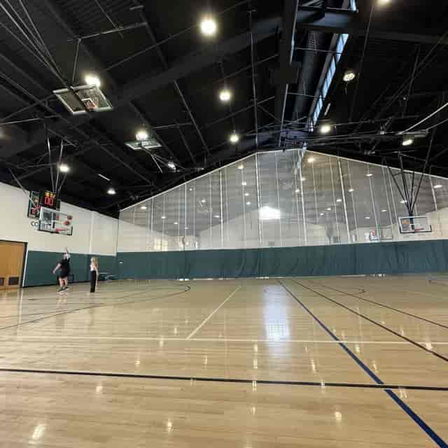 Indoor basketball gym with polished floor, ideal for corporate events and sports activities.