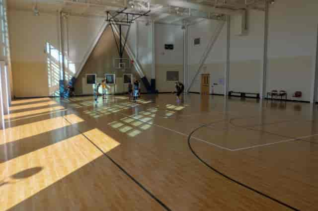 Spacious gym with polished floors for Open Gym Basketball events at Peninsula Community Center.