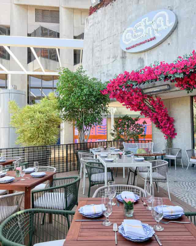 Outdoor dining at Osha Lounge, featuring lush greenery and elegant setting for events.