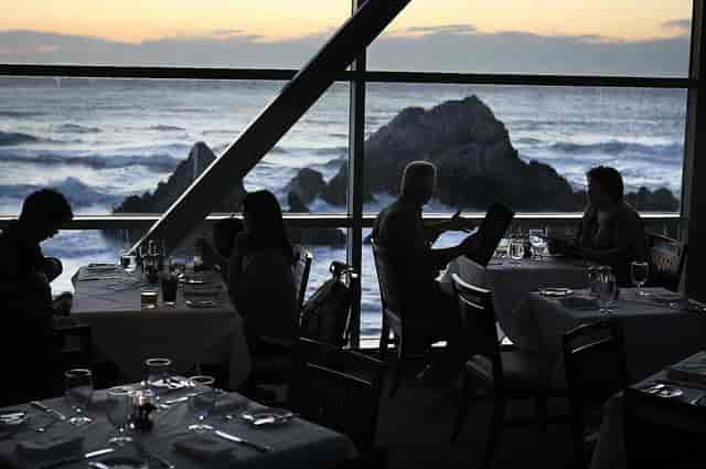 Main Dining Area at Cliff House, elegant tables, ocean view, ideal for corporate dinners.
