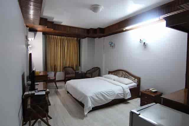 Spacious hotel room with natural light, ideal for conference attendees and event planners.