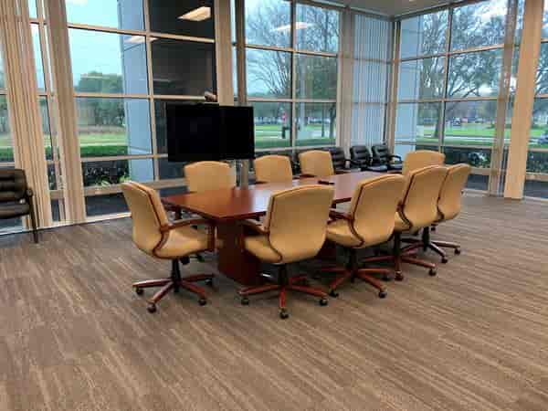 Private conference room with large wooden table at Golf Club of Houston for meetings.