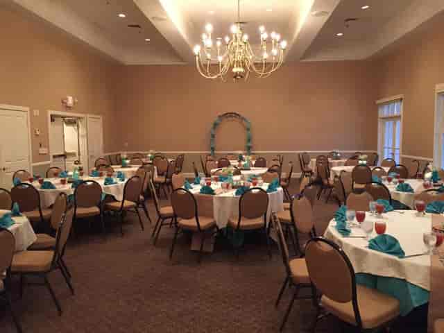 Elegant banquet room in The Club at Pecan Grove with circular tables for events.