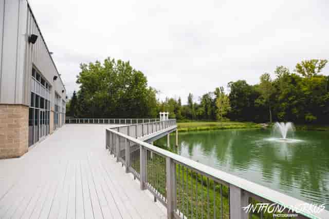 Spacious outdoor deck at The Pinnacle Center for events near serene pond and fountain.