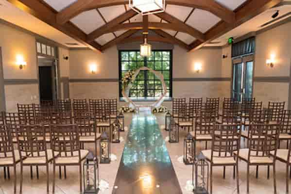 Elegant wedding ceremony setup at The ARK with floral archway and natural lighting.
