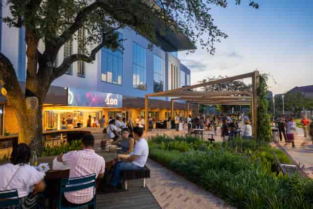Vibrant outdoor networking event at The Ion, featuring modern architecture and communal tables.