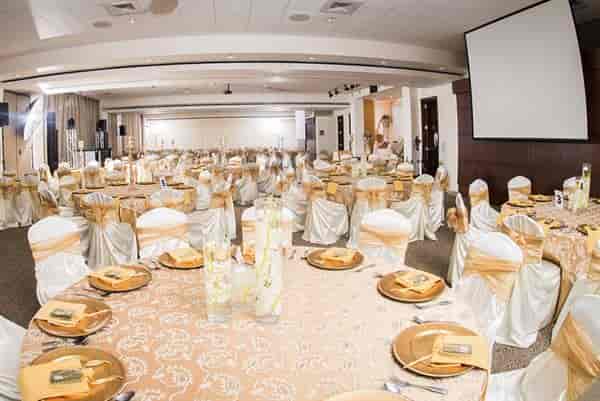 Elegant banquet hall with gold decor, perfect for weddings and corporate events.