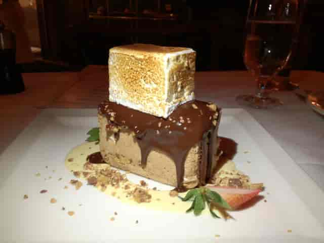 Elegant chocolate mousse dessert with toasted marshmallow for upscale event catering.