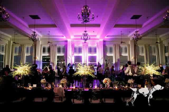 Elegant Main Ballroom with purple lighting, floral centerpieces for upscale events.