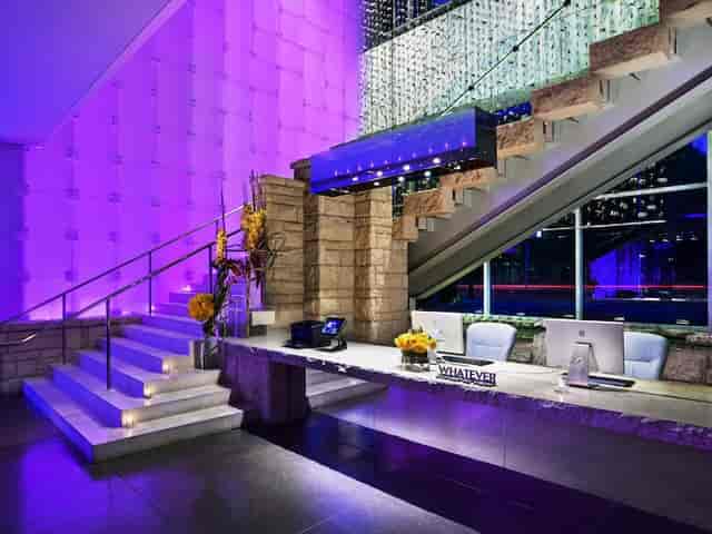 Modern reception area with marble desk and purple lighting at W Dallas Studio 2.