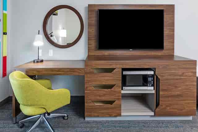 Modern meeting room with sleek desk and vibrant green chair at Hampton Inn Dallas.