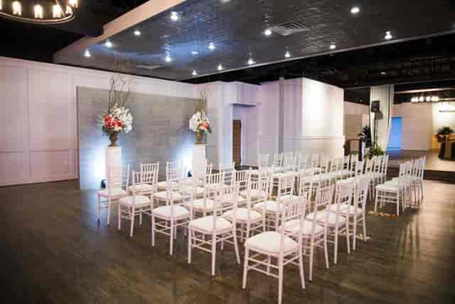 Elegant covered patio with white chairs, ideal for weddings and formal events.