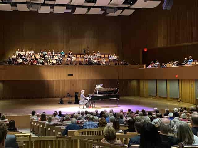 Van Cliburn Concert Hall concert with engaging pianist and warm wood paneling ambiance.