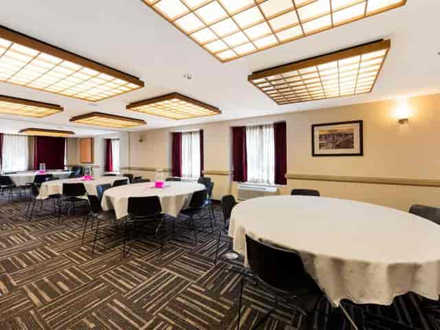 Conference room with round tables, ideal for workshops and seminars at Red Roof.