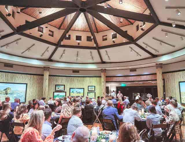Portraits of the Wild Art Gallery dinner event with elegant round tables and artwork.