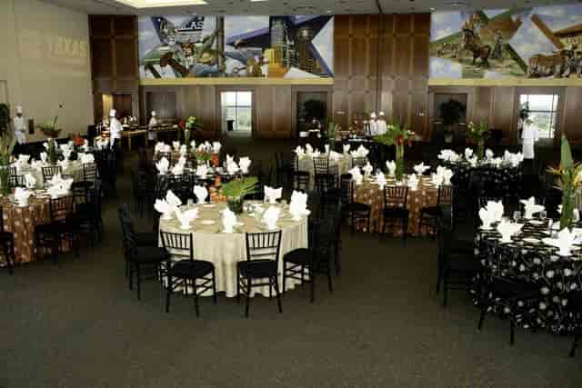 Elegant event space at The Speedway Club with round tables and floral centerpieces.