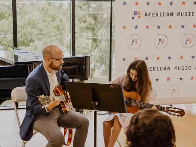 Intimate American music performance at AMA Houston with guitar musicians.