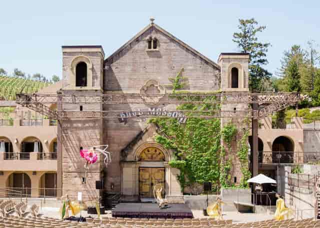 Outdoor event venue at The Mountain Winery with historic stone building and scenic backdrop.
