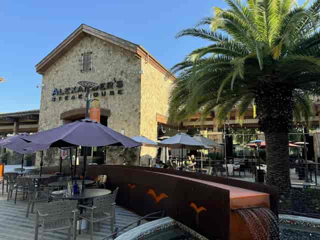 Outdoor dining area at Alexander's Steakhouse with shaded seating for events.