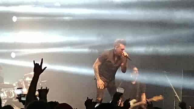Dynamic live performance in a ballroom with dramatic lighting and enthusiastic crowd.