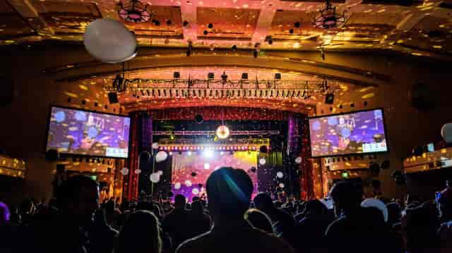 Amusement center event with dynamic lighting, balloons, and confetti celebration.