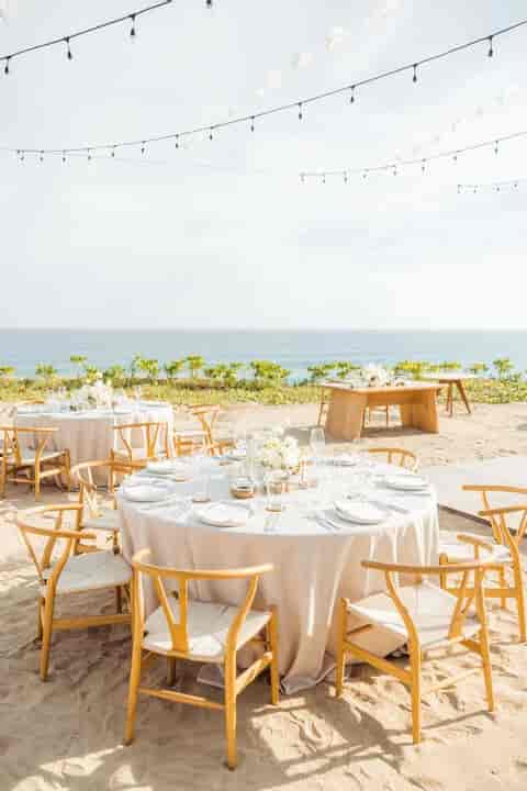 Elegant seaside event setup with floral centerpieces, perfect for weddings or retreats.
