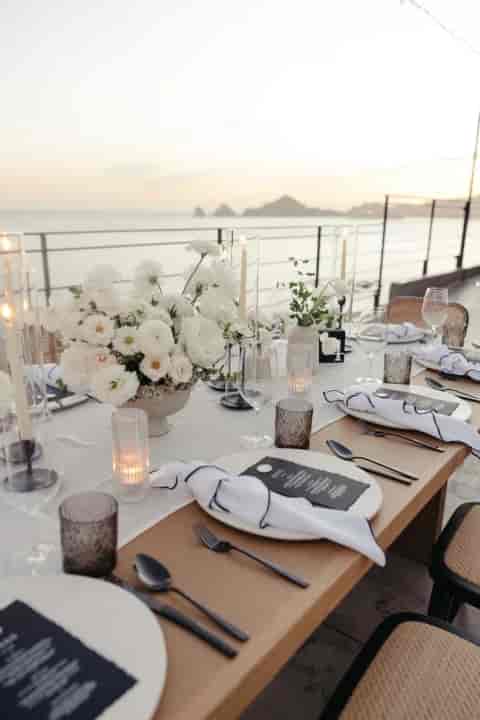 Elegant dining table with floral centerpieces for upscale beach events and receptions.