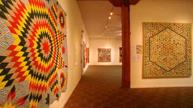 Vibrant gallery of colorful quilts in San Jose Museum, perfect for creative events and workshops.