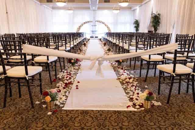 Elegant wedding banquet hall with floral aisle and chiavari chairs at Villa Ragusa.