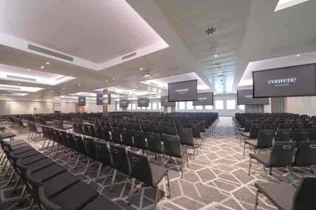 Spacious conference room with screens, ideal for events and seminars at Convene 133 Houndsditch.
