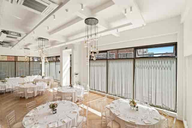 Elegant event space at The Ropewalks Hotel with bright ambiance and round tables.