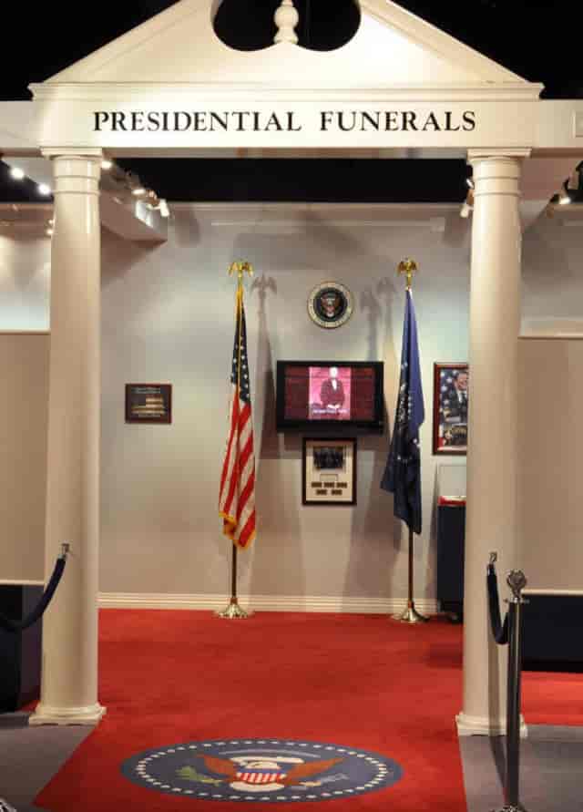 Auditorium at National Museum of Funeral History for formal events with presidential seal.