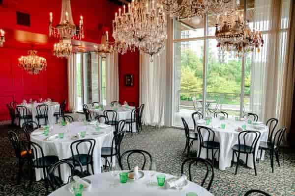 Elegant dining room with round tables and chandeliers for private events at Flora Mexican Kitchen.