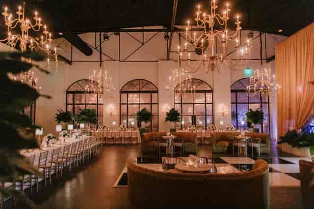 Event planner in elegant venue with chandeliers for weddings and corporate events.