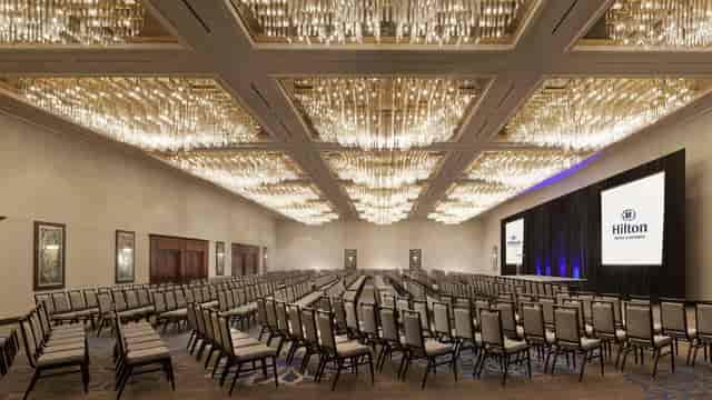 Elegant Hilton Fort Worth ballroom with chandelier for corporate events and conferences.