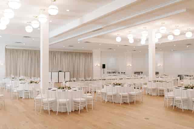 Spacious, elegantly designed ballroom for weddings and corporate events with natural light.