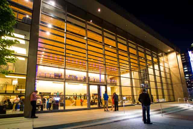 Moody Performance Hall at night, featuring modern glass architecture for events and presentations.