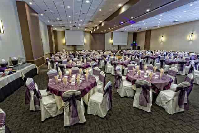 Elegant Red Oak Ballroom B with round tables and purple sashes, perfect for banquets.