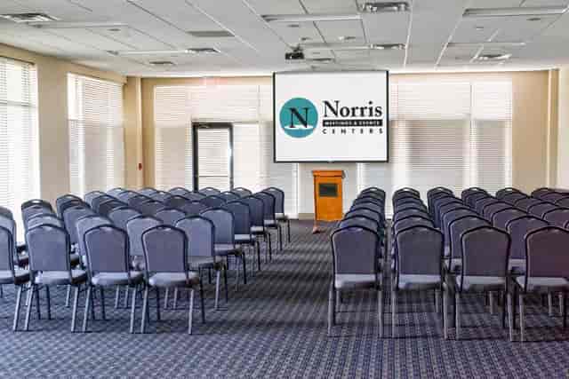 Alt text: Red Oak Ballroom conference setup with chairs and large screen for corporate events.