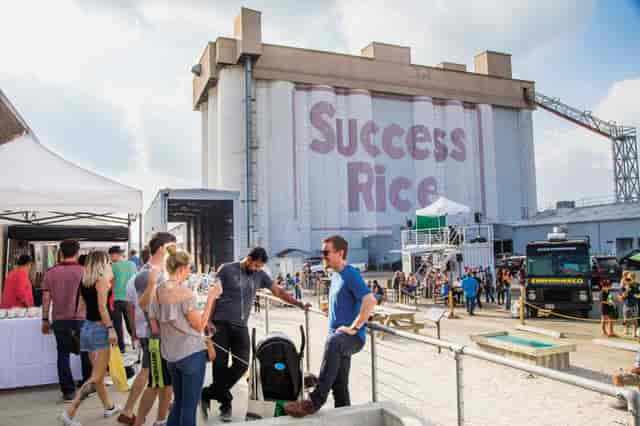Outdoor event at SITE Gallery Houston with vibrant mural, perfect for networking.