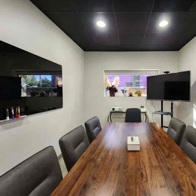 Modern training room with large table and screens for meetings in Houston.